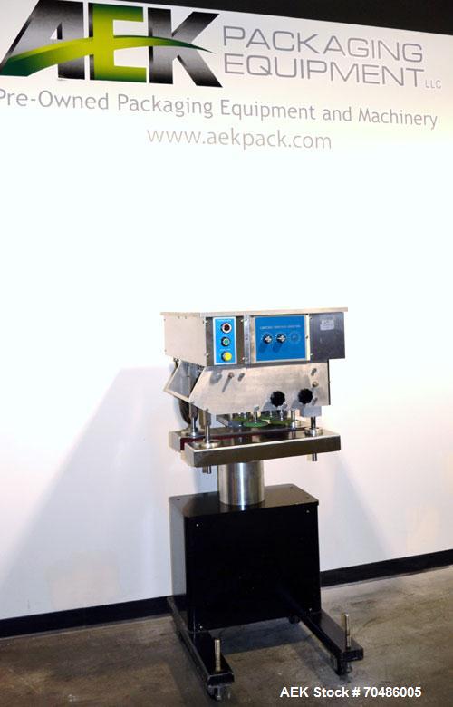 Used Filamatic (National Instruments) Model DL-4-CT 4 Quill Automatic Cap Tightening Machine. Capable of 80 containers per minute. (2) 2’’ Widex 19’’ long gripper belts, driven by a 1/2 hp, 90 volt D...
