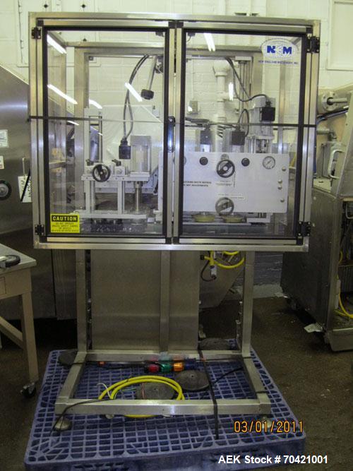 Used New England Machinery Cap Tightener and Retorquer, Model NEPMTE-1F-DB-2. Has dual cap tightening spindles. Single belt grippers. Cap size range:  12 mm to 100 mm or .5" to 4".  Container speeds ...