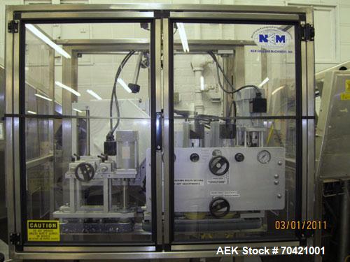 Used New England Machinery Cap Tightener and Retorquer, Model NEPMTE-1F-DB-2. Has dual cap tightening spindles. Single belt grippers. Cap size range:  12 mm to 100 mm or .5" to 4".  Container speeds ...