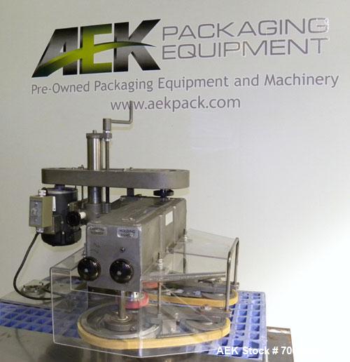 Used Kinsley Universal Roll-Tite Semi- Automatic Two Spindle Cap Tightener/ Retorquer, Model DM4350. Capable of speeds up to 200 containers per minute. Cap size range maximum 5-3/8’’ diameter without...