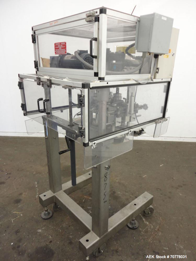Used Resina Model RT-20 cap tightener retorquer. Capable of speeds up to 90 bottles per minute. Cap size range: 13mm to 38mm. C frame desing, has two sets of cap tightening wheel, single side belt gr...