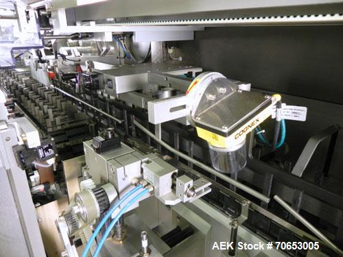 Used Uhlmann Model C2205 Automatic Bottle Cartoner. Capable of speeds up to 250 cartons per minute. Is a continuous motion cartoner. Has a 5" pitch for a Maximum carton size range: (Length) 150mm (6"...