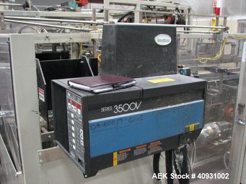Used Smurfit-Stone Packomatic Model 1588 Case Former and Packer. New 2002. Up to 25 cases per hour, maximum case size 24" long x 16" wide x 20" deep, Nordson series 3500V gluer.