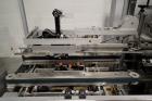 Used Skinetta Top Loading Case Erector Packer, Model CP 150. Servo driven loading head, with powered case feeder and case erector. Integrated top and bottom case taper. Includes controls. 3/60/480 Vo...