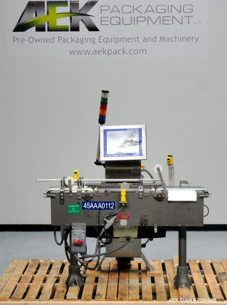Used Mettler Toldeo XS Hi Speed Chain Checkweigher, Model CM9400-CM. Has the capacity to weigh up to 50 lbs., with a weigh pan length of 13". Currently set up to run 140 PPM, for carton size of 5.38"...