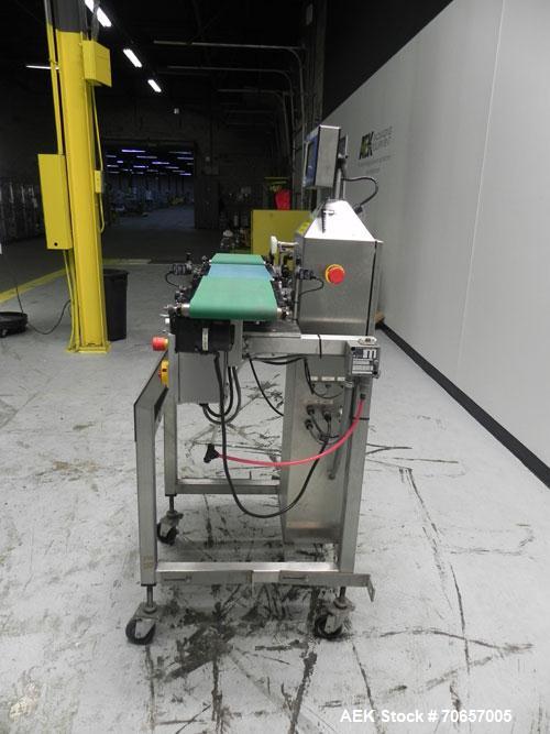 Used Lock Model Weigh Chek CK2500 Belt Checkweigher. Machine is capable of speeds up to 300 cases per minute (dependent on case size). Has a package weight range of 10 of 2500 g and a weight cell cap...