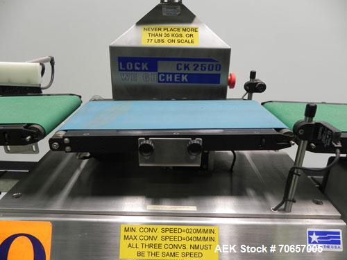 Used Lock Model Weigh Chek CK2500 Belt Checkweigher. Machine is capable of speeds up to 300 cases per minute (dependent on case size). Has a package weight range of 10 of 2500 g and a weight cell cap...