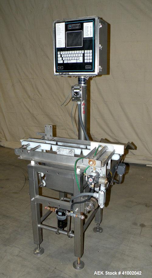 Used Whitney Packaging/Processing Corp Datachek Checkweigher, Model DC-300M. Capable of speeds up to 300 CPM and weights up to 3Kg or 6.6 lbs. Accuracies of +/- 1 gram or .5%. Left to right operation...
