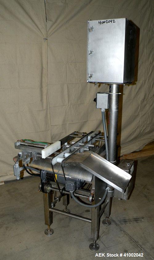 Used Whitney Packaging/Processing Corp Datachek Checkweigher, Model DC-300M. Capable of speeds up to 300 CPM and weights up to 3Kg or 6.6 lbs. Accuracies of +/- 1 gram or .5%. Left to right operation...