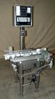 Used Whitney Packaging/Processing Corp Datachek Checkweigher, Model DC-300M. Capable of speeds up to 300 CPM and weights up to 3Kg or 6.6 lbs. Accuracies of +/- 1 gram or .5%. Left to right operation...