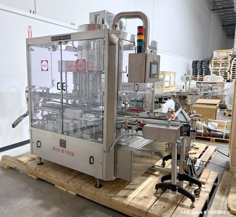 Used Capmatic Bottling Line, Model Verifill. Line consists of: (1) Capmatic Bottle Cleaner, (1) Capmatic rotary chuck capper, model Roadrunner 4HM, (1) LSI pressure sensitive wraparound labeler, mode...