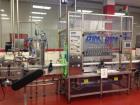 Used 2 oz. Energy Shot Bottle Filling Line. Includes: New England Model NEHCPCL bottle unscrambler with bottle elevator, capable of 250/minute. DTM Purefil 2000 12-head straightline continuous motion...