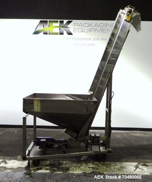 Used Hoppmann Cap Elevator, Stainless Steel. 5” wide x 102” long rubber belt, approximate 108” discharge height. Hopper approximate 46” x 38” x 28” deep. Hinged plexiglass top cover. Driven by a 1/4h...
