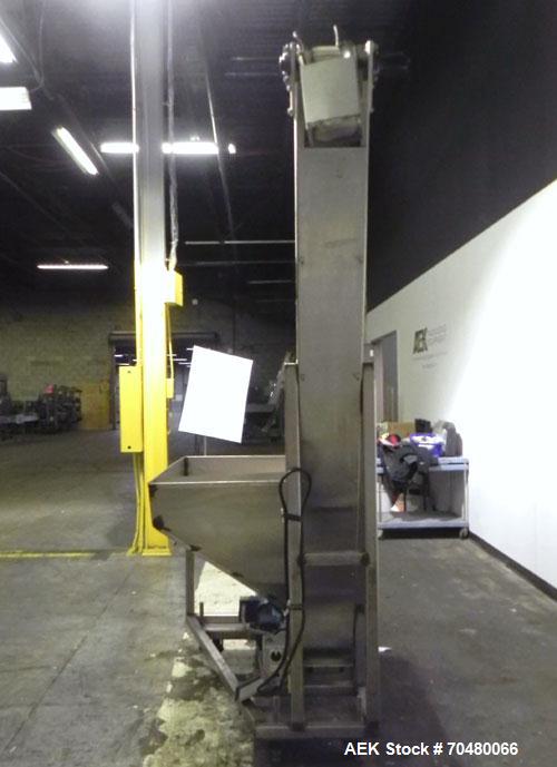 Used Hoppmann Cap Elevator, Stainless Steel. 5” wide x 102” long rubber belt, approximate 108” discharge height. Hopper approximate 46” x 38” x 28” deep. Hinged plexiglass top cover. Driven by a 1/4h...