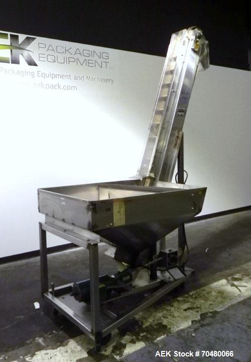 Used Hoppmann Cap Elevator, Stainless Steel. 5” wide x 102” long rubber belt, approximate 108” discharge height. Hopper approximate 46” x 38” x 28” deep. Hinged plexiglass top cover. Driven by a 1/4h...