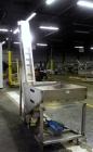 Used Hoppmann Cap Elevator, Stainless Steel. 5” wide x 102” long rubber belt, approximate 108” discharge height. Hopper approximate 46” x 38” x 28” deep. Hinged plexiglass top cover. Driven by a 1/4h...