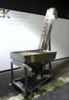Used Hoppmann Cap Elevator, Stainless Steel. 5” wide x 102” long rubber belt, approximate 108” discharge height. Hopper approximate 46” x 38” x 28” deep. Hinged plexiglass top cover. Driven by a 1/4h...