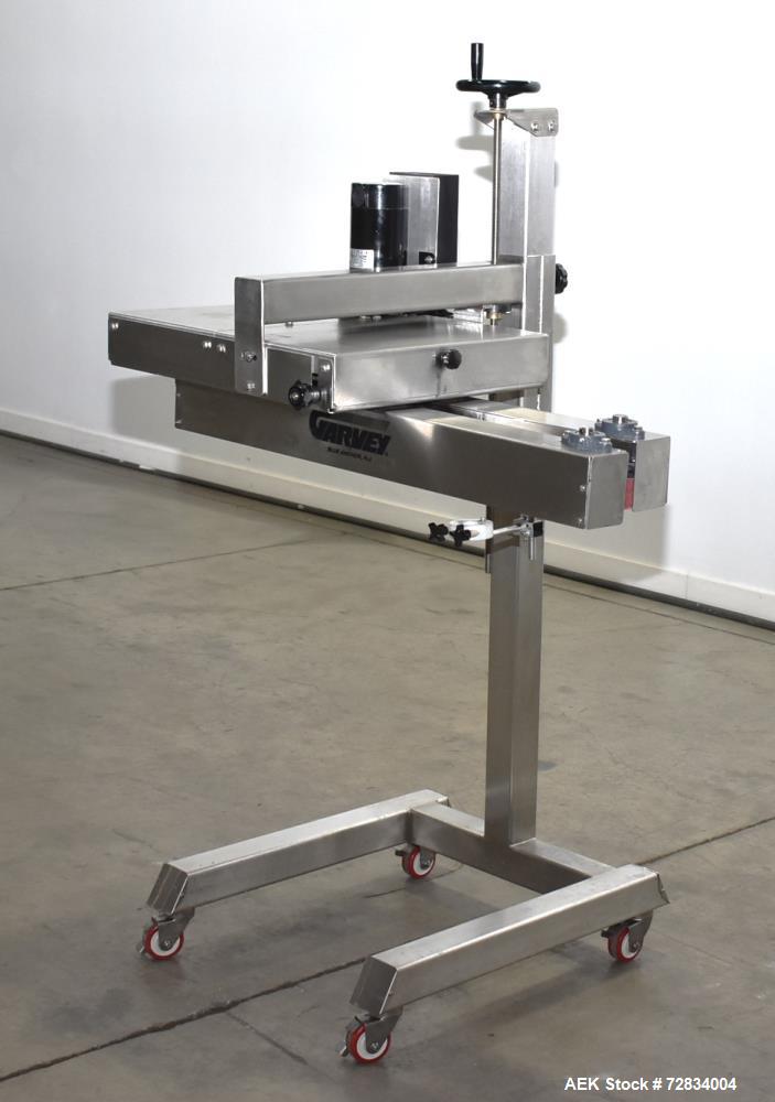 Used Garvey Side Belt Gap Transfer Conveyor. (2) Belts, approximate 39" long x 2" wide. Adjustable height. Mounted on casters. Last used with Video Jet coder for bottom date coding. 1/60/115 Volt.