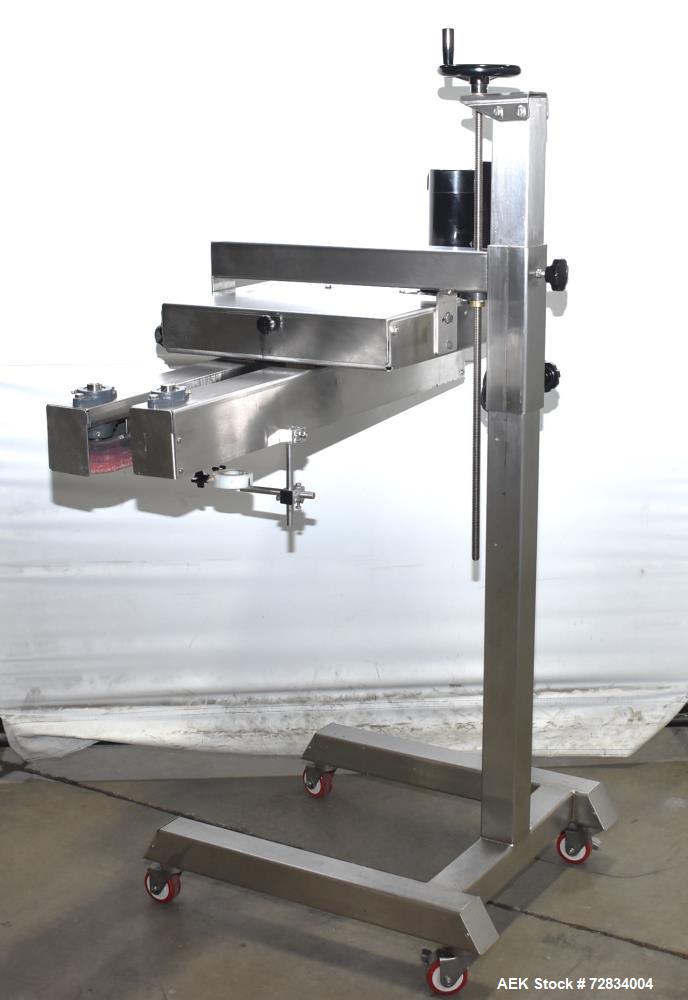 Used Garvey Side Belt Gap Transfer Conveyor. (2) Belts, approximate 39" long x 2" wide. Adjustable height. Mounted on casters. Last used with Video Jet coder for bottom date coding. 1/60/115 Volt.