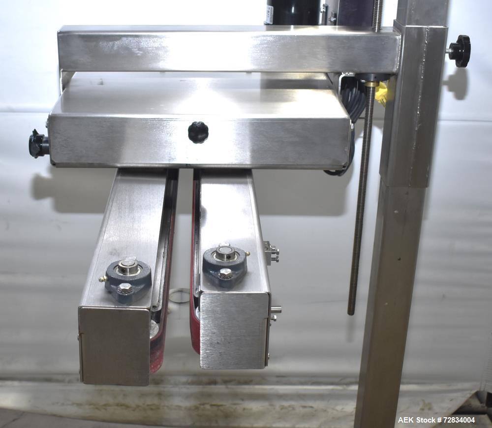 Used Garvey Side Belt Gap Transfer Conveyor. (2) Belts, approximate 39" long x 2" wide. Adjustable height. Mounted on casters. Last used with Video Jet coder for bottom date coding. 1/60/115 Volt.