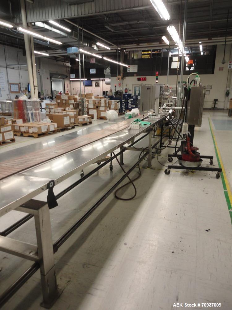 Used Pack Out Conveyor, 30 feet long (approximately) by 12” wide tall table top chain, with dual stainless steel side pack out shelves.