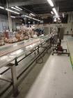 Used Pack Out Conveyor, 30 feet long (approximately) by 12” wide tall table top chain, with dual stainless steel side pack out shelves.