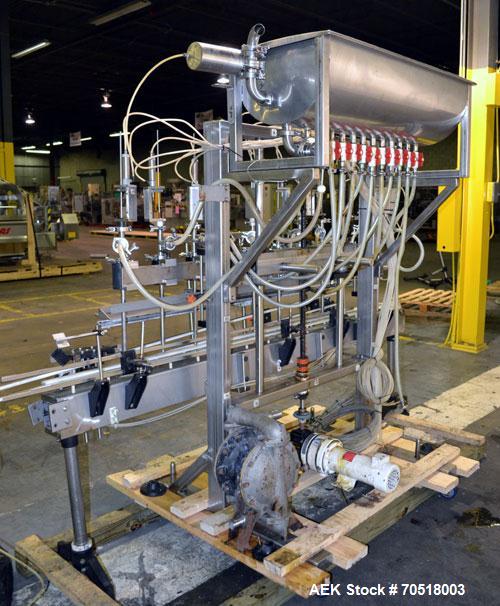 Used Fluid Packaging Solutions 12 Head Inline Automatic Time / Gravity Liquid Filler. Fabricated with 4-1/2" wide x 180" long table top chain conveyor, 5/8" nozzles with positive shut-off valves, div...