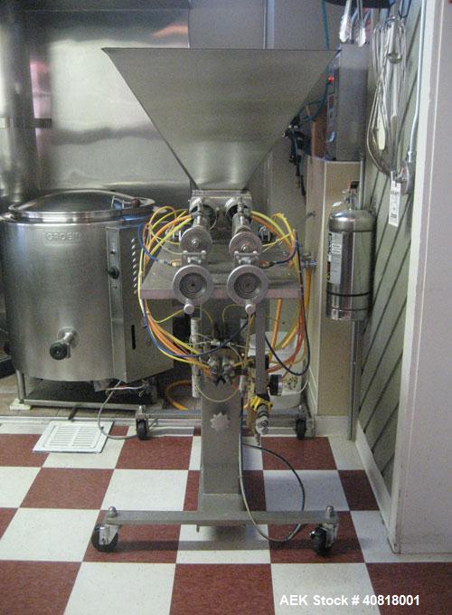 Used Hinds-Boch Twin Head Piston Filling Machine with hopper, on casters. Equipped withdual 32oz pistons, pneumatic foot pedal actuation.