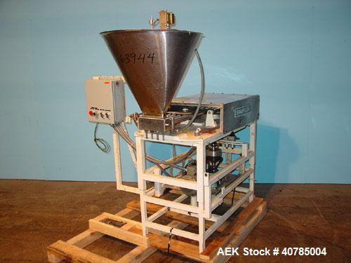 Used Simplex 4 Head Filler. Stainless steel nozzles 2" long x 3/16" opening, approximate 12 oz capacity per stroke, 28" diameter x 24" deep stainless steel hopper with cover. Mounted on a carbon stee...
