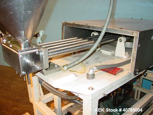 Used Simplex 4 Head Filler. Stainless steel nozzles 2" long x 3/16" opening, approximate 12 oz capacity per stroke, 28" diameter x 24" deep stainless steel hopper with cover. Mounted on a carbon stee...
