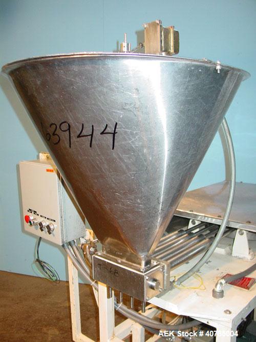 Used Simplex 4 Head Filler. Stainless steel nozzles 2" long x 3/16" opening, approximate 12 oz capacity per stroke, 28" diameter x 24" deep stainless steel hopper with cover. Mounted on a carbon stee...