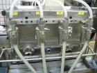 Used Filamatic 4 head inline piston filler. Has pin indexing system, bottom up fill, 240cc pistons, 10'L conveyor. Mounted on casters.