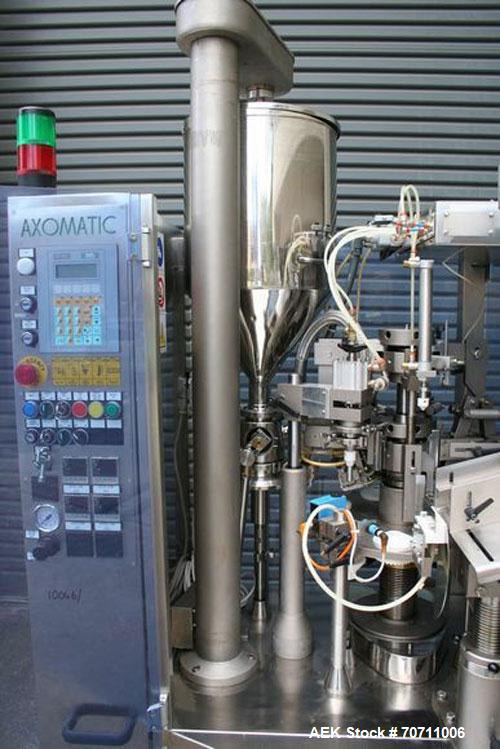Used Axiomatic Model Optima 700 Axomatic Tube Filler. 7 Station, water cooled hot jaws, hopper with agitator, maximum speed of 2,500 pieces/hour, automatic tube positioning, fixed nozzle with bush-ra...