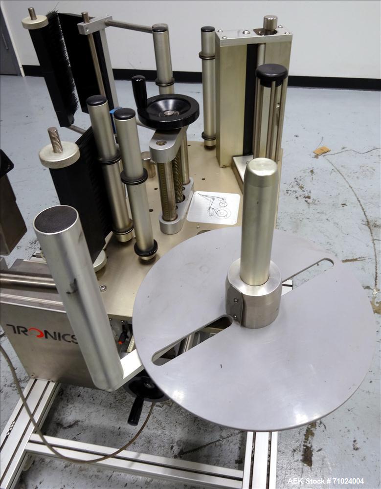 Used Tronics Model S1000 Stand Alone Pressure Sensitive Labeler. Capable of speeds up 1,200" per minute. Has maximum label height of 8.5". Equipped with 9.5" peel plate, tronics hmi, and label sensor...