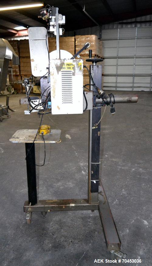 Used LSI Loose Loop Print & Apply Labeler, Model 1360, capable of 120 products per minute. Can accommodate up to 4" x 4" labels. Foot pedal controls. Mounted on a stand with casters. Missing printer....