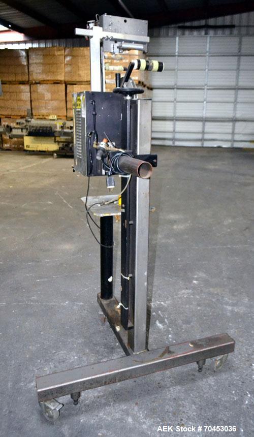 Used LSI Loose Loop Print & Apply Labeler, Model 1360, capable of 120 products per minute. Can accommodate up to 4" x 4" labels. Foot pedal controls. Mounted on a stand with casters. Missing printer....