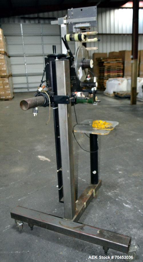 Used LSI Loose Loop Print & Apply Labeler, Model 1360, capable of 120 products per minute. Can accommodate up to 4" x 4" labels. Foot pedal controls. Mounted on a stand with casters. Missing printer....