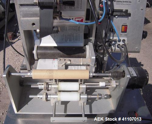 Used Labeling Systems Inc (LSI) Semi Automatic Wrap Around Labeler, Model 301S. Designed for semi automatic wrap around labeling of products such as bottles, vials or cans. Maximum bottle size 12" hi...