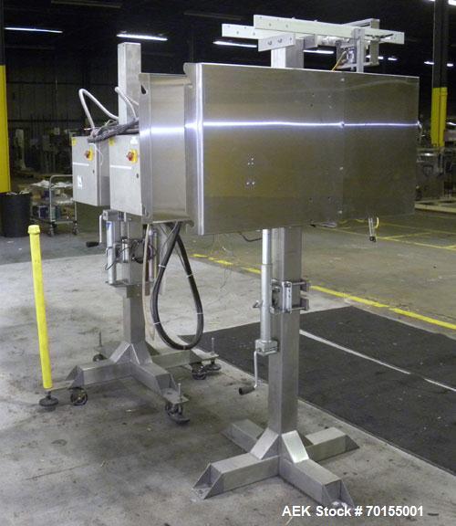 Used Axon Corporation EZ-100 Tamper Evident Band and Sleeve Label Applicator capable of speeds up to 150 packages per minute. Stainless steel design. Has vertical perforation, power unwind station an...