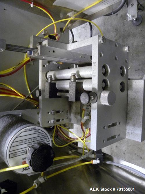Used Axon Corporation EZ-100 Tamper Evident Band and Sleeve Label Applicator capable of speeds up to 150 packages per minute. Stainless steel design. Has vertical perforation, power unwind station an...
