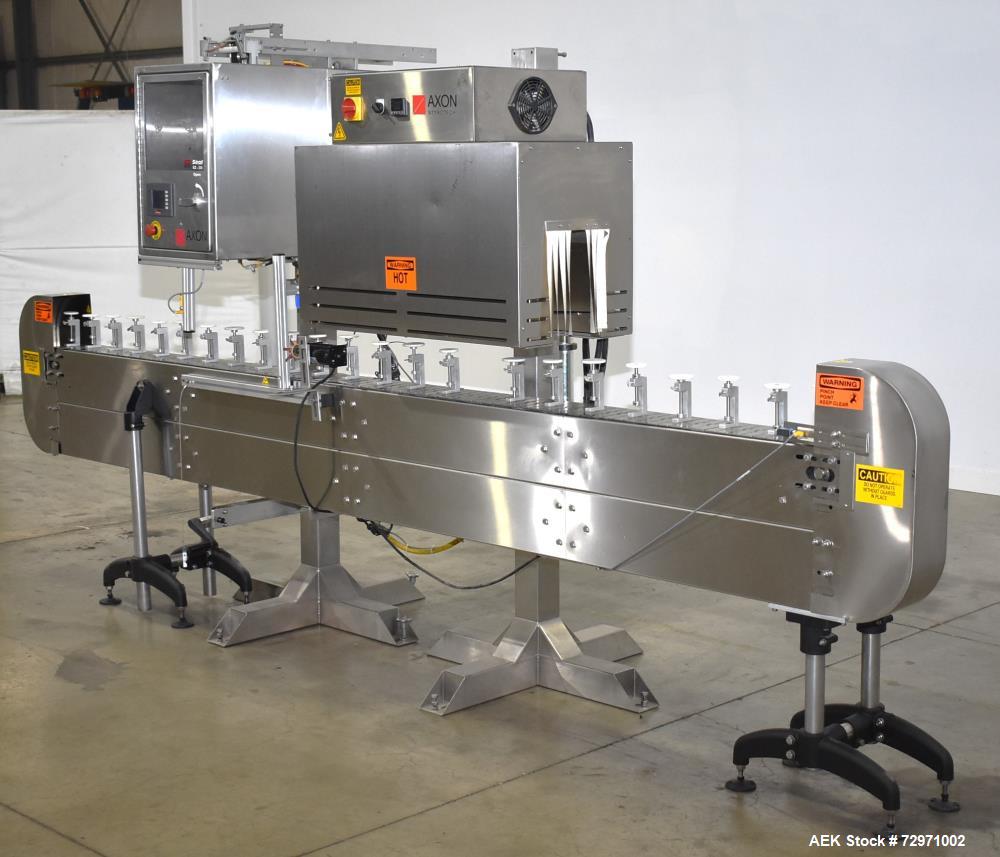 Used Axon Styrotech EZ-Seal EZ-200 Single Head Tamper Evident Neck Bander. Designed to run up to 120 containers per minute. 1-60/115 volt, 10 amp, serial # T-100210B, built 05/2010. Includes a heat s...