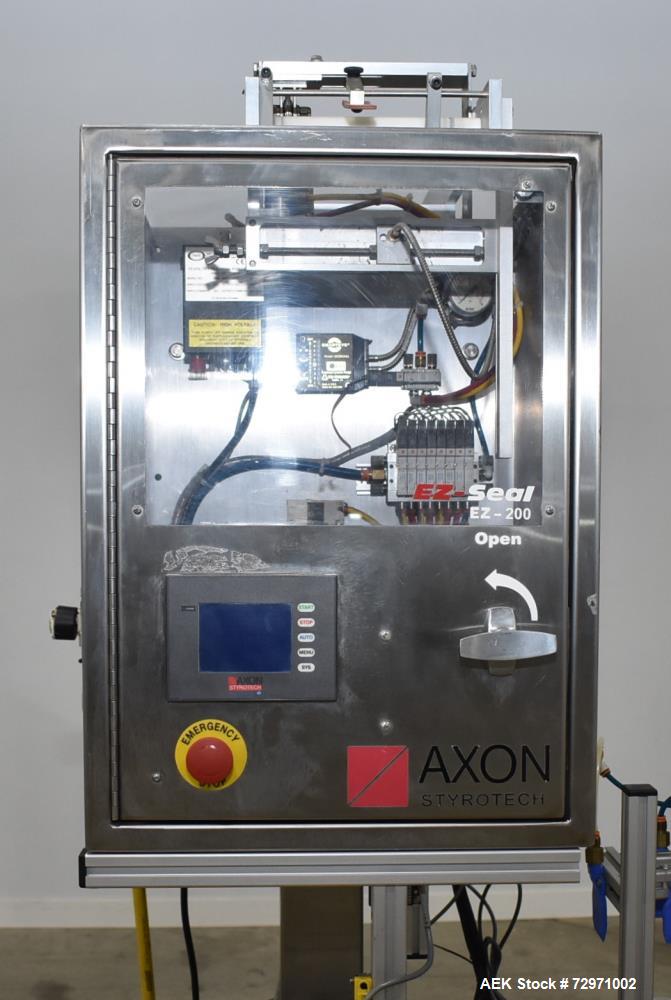 Used Axon Styrotech EZ-Seal EZ-200 Single Head Tamper Evident Neck Bander. Designed to run up to 120 containers per minute. 1-60/115 volt, 10 amp, serial # T-100210B, built 05/2010. Includes a heat s...