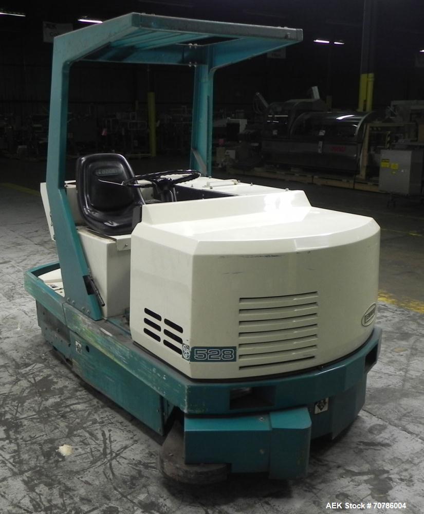 Used- Tennant Model 528 SRS Edition Riding Floor Scrubber. Has a 4-cycle propane powered engine. Has 122 gallon solution tan...