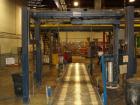Used Cousins Automatic Stretch Wrapper, Model 7100-65-OHA. The Series 7100 fully automatic conveyorized overhead spiral stretch wrap systems will wrap up to 95 loads per hour, maximum load size 50” w...