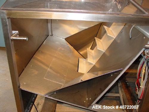 Used Kalish Bottle Unscrambler, model 7400, stainless steel. Feeds containers at up to 100 CPM, 42'' x 32'' x 22'' bulk hopper with 12'' x 28'' flighted rubber elevator belt, 3'' flights spaced 6'' o...