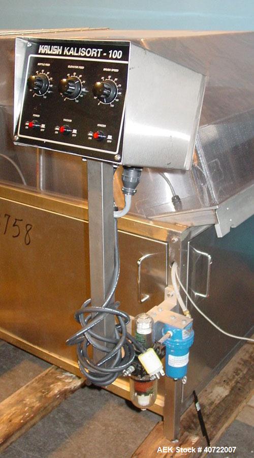 Used Kalish Bottle Unscrambler, model 7400, stainless steel. Feeds containers at up to 100 CPM, 42'' x 32'' x 22'' bulk hopper with 12'' x 28'' flighted rubber elevator belt, 3'' flights spaced 6'' o...