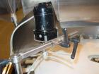 Used Kalish Bottle Unscrambler, model 7400, stainless steel. Feeds containers at up to 100 CPM, 42'' x 32'' x 22'' bulk hopper with 12'' x 28'' flighted rubber elevator belt, 3'' flights spaced 6'' o...