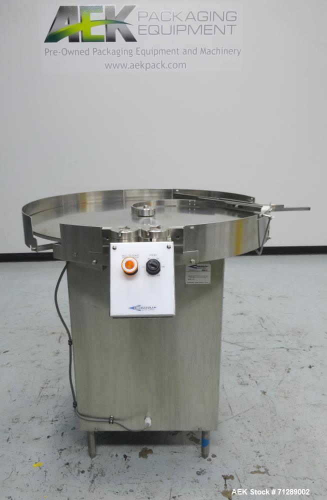 Used Cozzoli Machine Company Rotary Unscrambling/Accumulation Table, Model UT-AT36. 36" Diameter. Has adjustable speed control. Stainless steel construction. Mounted on  (4) legs.