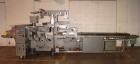 Used Doboy Horizontal Wrapper, Model J. Capable of speeds over 200 packages per minute. Has extended height seal, side belt product infeed belts, film registration, 1 up sealing head 8