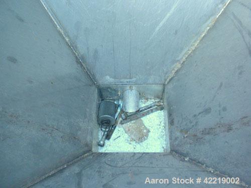 Used NBE Dry Bulk Storage Hopper, approximately 40 cubic feet, carbon steel. 44" wide x 44" long x 18" deep x coned bottom. Approximate 1400 pound capacity. Includes a top extension and grate. Mounte...